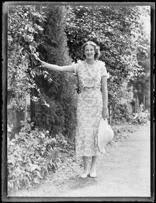 Model Margaret Vyner standing in a garden holding a hat, New South Wales, 21 March 1934 [picture]
