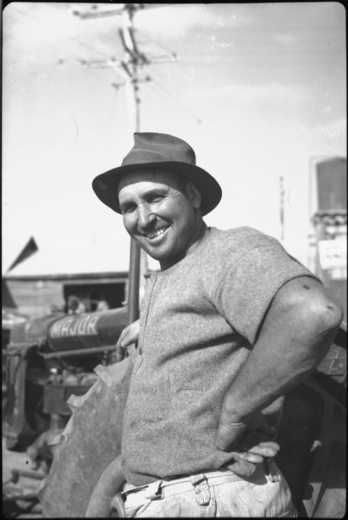 [A man leaning on a tractor, Queensland] [picture] / [Frank Hurley]