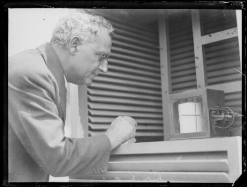 Mr. D.J. Mares of the Weather Bureau reading one of the instruments, New South Wales, ca. 1931 [picture]