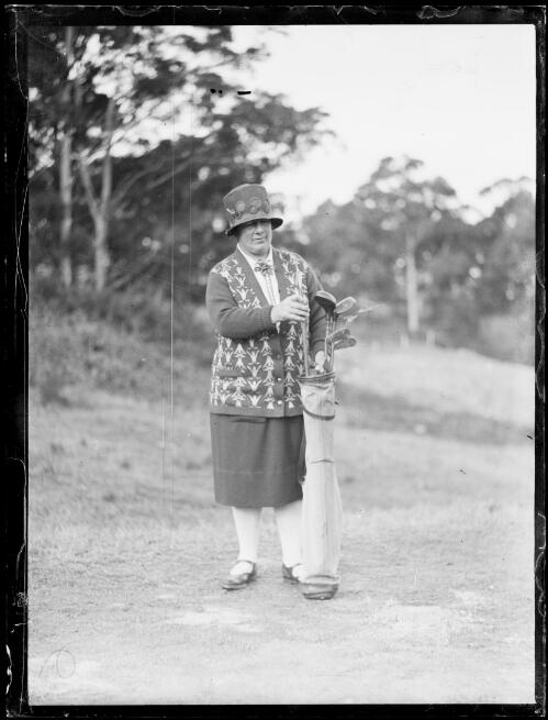 Mrs Triglone of the Manly Golf Club choosing a golf club, New South Wales, ca. 1925 [picture]