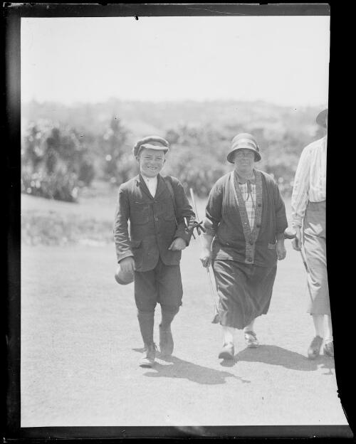 Mrs Triglone of the Manly Golf Club walking with her caddy, New South Wales, ca. 1925 [picture]