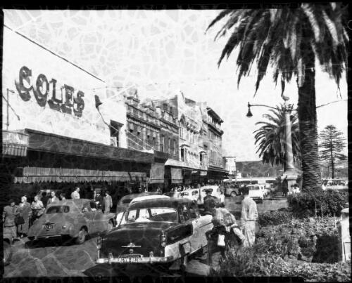 [People in a street, cars FZ421, GVM883 Coles, trees, Manly?] [picture] : [Manly, New South Wales] / [Frank Hurley]