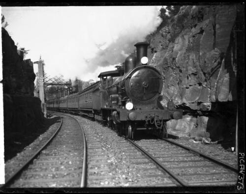 [Passenger train hauled by a P class steam locomotive coming off old Hawkesbury River Bridge, Sydney to Newcastle, pre-1946] [picture] : [New South Wales] / [Frank Hurley]