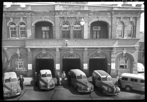 [Queensland Ambulance Transport Brigade Hospital with 6 ambulance officers, 5 ambulances and another figure] [picture] : [Brisbane, Queensland] / [Frank Hurley]