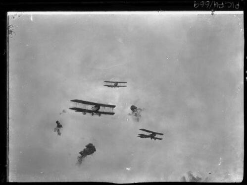 [Three British biplanes and anti-aircraft shell bursts in the sky over Zonnebeke, Flanders, October 1917] [picture] : [Flanders, World War I] / [Frank Hurley]
