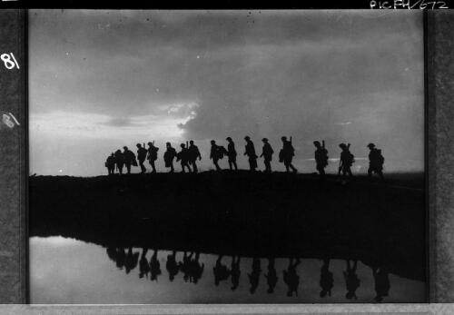 Infantry moving forward to take up front line positions at evening, their images reflected in a rain-filled crater at Hooge, October, 1917 [picture] / [Frank Hurley]
