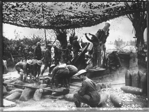 [Group of soldiers under a camoflage net, loading shells into a field gun] [picture] : [World War I] / [Frank Hurley]