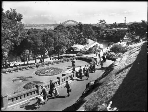 Scenic view of Baths from the Seal Lake with floral clock [picture] : [Taronga Park Zoo, Sydney, New South Wales] / [Frank Hurley]