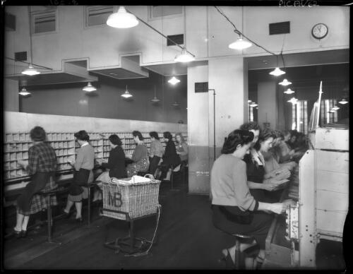 The Inland Section, sorters engaged in sorting letters [General Post Office, Martin Place, Sydney, 1940s] [picture] : [Sydney, New South Wales] / [Frank Hurley]