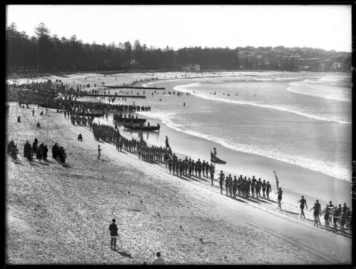March past along margin of surf Manly [Grand Parade of surf life savers, Surf Carnival, 1940s] [picture] : [Sydney, New South Wales] / [Frank Hurley]