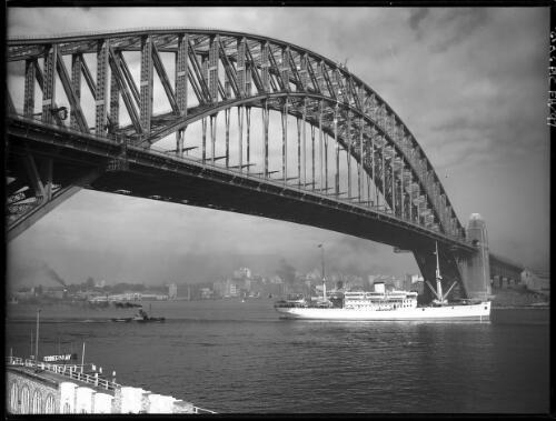 Dutch boat passing under Bridge [Sydney Harbour Bridge from Luna Park wharf with North Sydney swimming pool wall] [picture] : [Sydney Harbour, New South Wales] / [Frank Hurley]