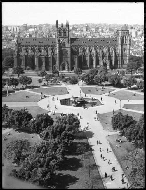 Exterior St Marys & Archibald Fountain from D.J. Bldg [David Jones building, Roman Catholic Cathedral, Hyde Park, 1940s] [picture] : [Sydney, New South Wales] / [Frank Hurley]