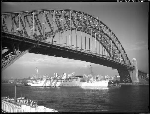 The Strathaird passing under Bridge [Sydney Harbour Bridge, showing two tug boats, and one ferry from Luna Park wharf] [picture] : [Sydney Harbour, New South Wales] / [Frank Hurley]