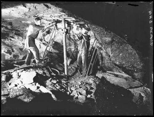 Another view of men operating drill 1700 feet below surface Zinc Corp [mining] [picture] : [Broken Hill, New South Wales] / [Frank Hurley]