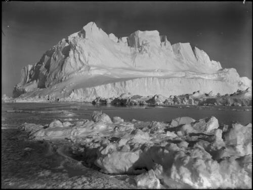 A mammoth berg rising like a castle of gleaming marble above the pack [Iceberg, Shackleton expedition, 1916] [picture] : [Antarctica] / [Frank Hurley]