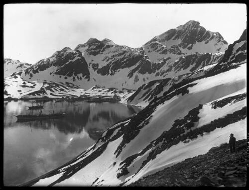 King Edward Cove, South Georgia [with man in cap with pipe, Shackleton expedition to Antarctica, 1914] [picture] : [Antarctica] / [Frank Hurley]