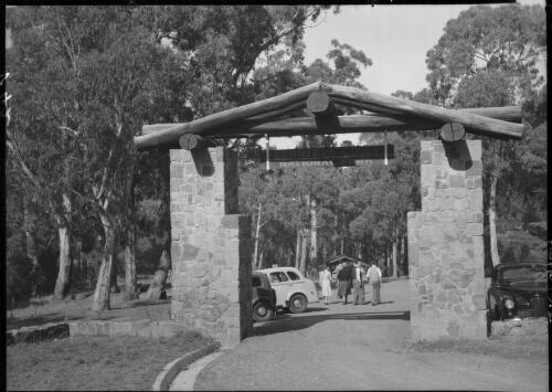 Fern Tree Gully Melbourne [Ferntree Gully National Park gate, carpark and figures] [picture] : [Victoria] / [Frank Hurley]