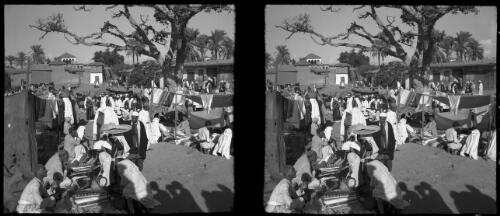 Village fair Esdud Palestine [men selling fabric in the foreground] [picture] / [Frank Hurley]