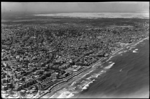 Tel Aviv Aerial looking N.E. [beach, surf and bathers, buildings and a promenades] [picture] / [Frank Hurley]