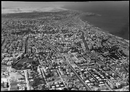 Aerial Tel Aviv looking towards Jaffa [tree-lined streets, apartments, surf beach] [picture] / [Frank Hurley]