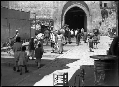 The Damascus Gate Jerusalem [figures passing on the road in and out of the gate] [picture] / [Frank Hurley]