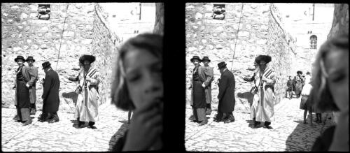 Orthodox Jews returning from Wailing Wall [four main figures, a face in the foreground, Jerusalem] [picture] / [Frank Hurley]