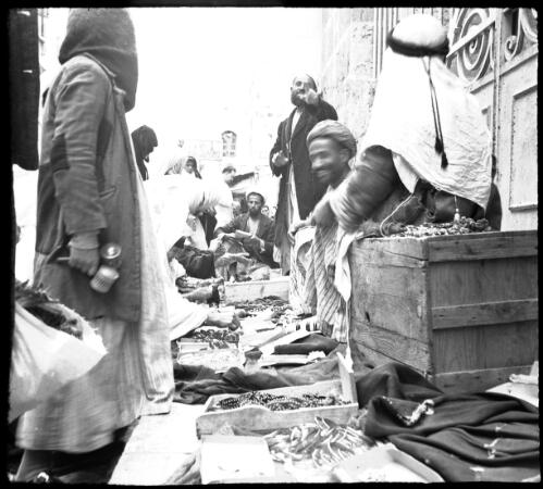 In the Bazaar Jerusalem [figures with wares spread on the ground] [picture] / [Frank Hurley]