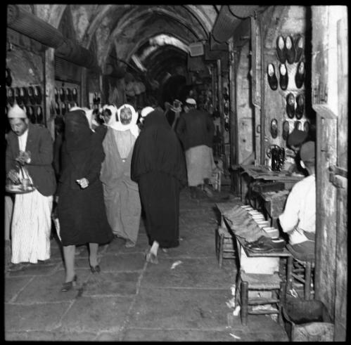 Jerusalem [beside a stall with shoes hanging on wall] [picture] / [Frank Hurley]