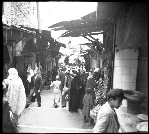 Jerusalem [figures in a narrow street, stalls and awnings] [picture] / [Frank Hurley]