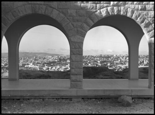 [Panorama of a city viewed from between stone arches and columns, Jerusalem? 2] [picture] / [Frank Hurley]