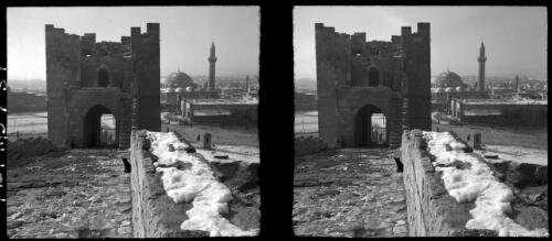 Aleppo [Syria, a stone wall, a high gate and a mosque] [picture] / [Frank Hurley]