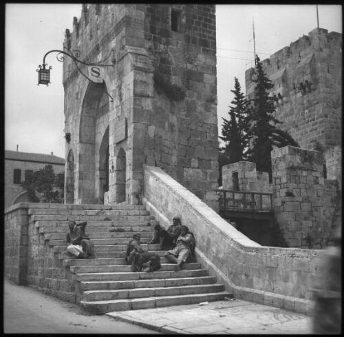 Few Jerusalem snaps [four figures seated on the steps of Herod's Citadel, gate, ca. 1940-1945] [picture] / [Frank Hurley]