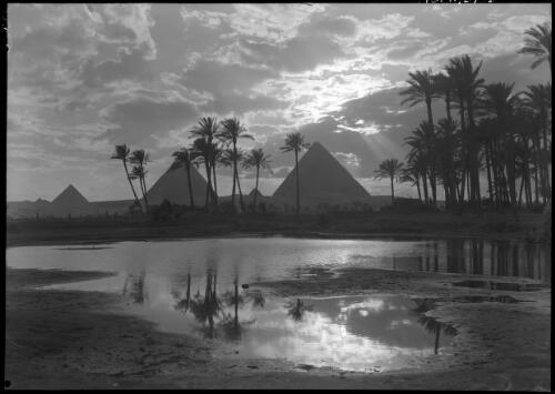 [Four pyramids in Egypt with palm trees and oasis in the foreground] [picture] / [Frank Hurley]