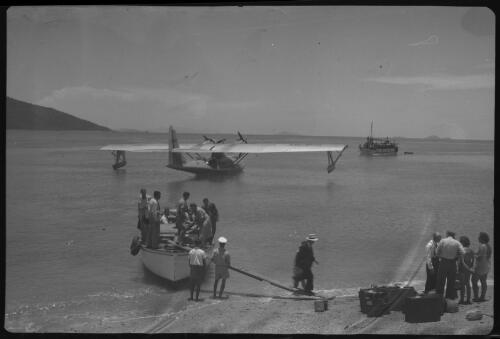 [Arrival of flying boat into bay, with people and luggage moved to shore, 1] [picture] / [Frank Hurley]