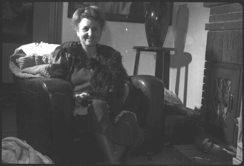 [Antoinette Hurley sitting in armchair with dog on lap] [picture] / [Frank Hurley]