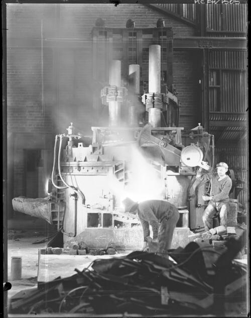 [Two men with machinery, an oven?, steam, pipes at an industrial plant, possibly B.H.P. Steelworks] [picture] : [Newcastle, New South Wales] / [Frank Hurley]