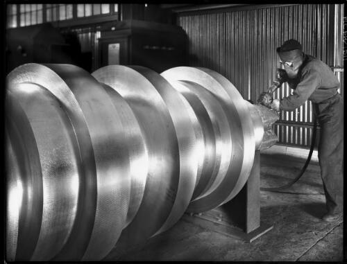 Trimming a roll for the mills, B.H.P. steel works [picture] : [Newcastle, New South Wales] / [Frank Hurley]