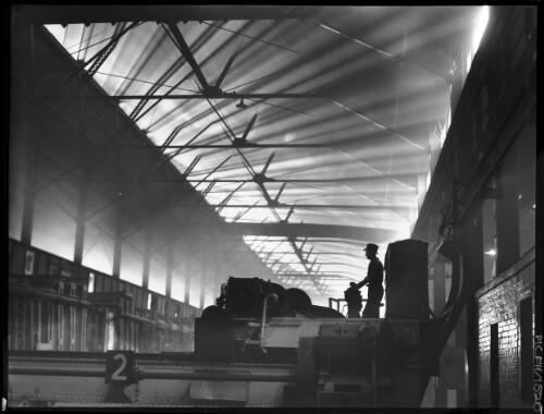 [Man with industrial machinery number 2, open hearth floor, in high-roofed building, B.H.P. Steelworks] [picture] : [Newcastle, New South Wales] / [Frank Hurley]