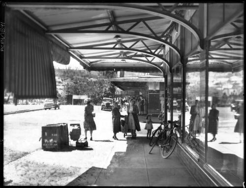 Shopping Centre [women and children with a pram, bicycles, reflections in a window and awnings, Yallourn, Victoria, December 1947] [picture] : [State Electricity Commission of Victoria] / [Frank Hurley]