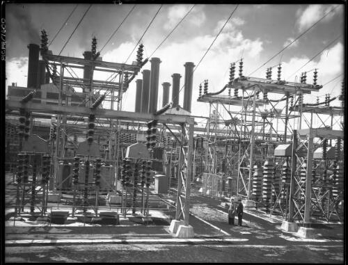 PS main switch yard (with two figures) [Power Station, Yallourn, Victoria, December 1947] [picture] : [State Electricity Commission of Victoria] / [Frank Hurley]