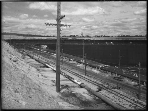 [Open cut coal mine, with telegraph poles on left, Yallourn, Victoria, December 1947] [picture] : [State Electricity Commission of Victoria] / [Frank Hurley]