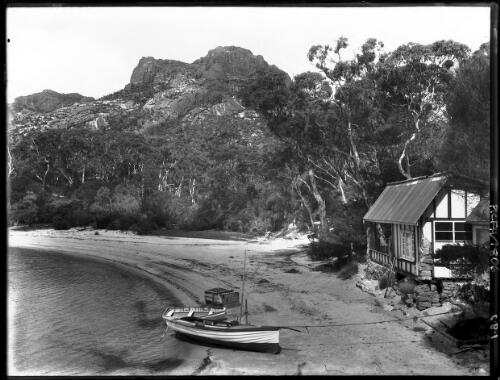 The Fishery [shore, boat, hut, trees] [picture] : [Coles Bay, Tasmania] / [Frank Hurley]