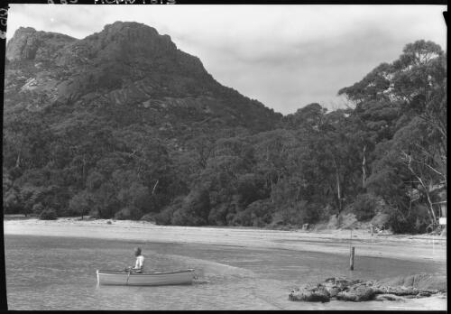 The Fisheries, Coles Bay [figure in boat] [picture] : [Coles Bay, Tasmania] / [Frank Hurley]