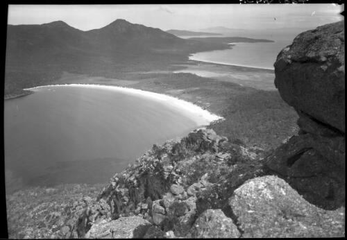 Wineglass Bay from Mt Amos [with rocky peak on right] [picture] : [Coles Bay, Tasmania] / [Frank Hurley]