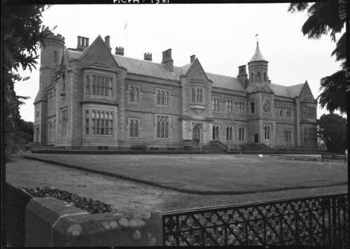 Various scenes Government House & Grounds [wrought iron fence with sprinkler and lawn] [picture] : [Hobart, Tasmania] / [Frank Hurley]