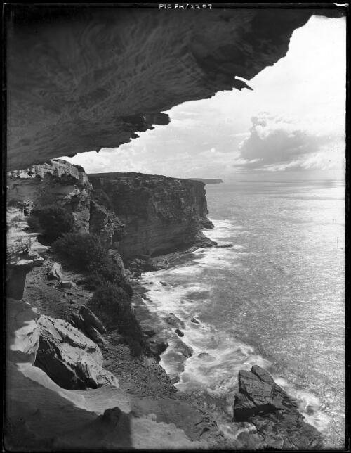 [Headlands and sea with rocky overhang] [picture] : [South Coast, New South Wales] / [Frank Hurley]