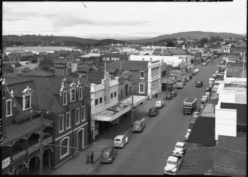 Rooke St. Devonport [shops, cars, a bus, figures] [picture] : [North West Coast, Tasmania] / [Frank Hurley]