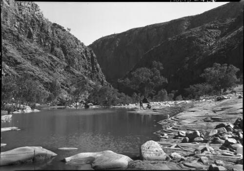 Entrance to Glen Helen [hills, rocks, waterhole or pool, figures] [picture] : [Central Australia] / [Frank Hurley]
