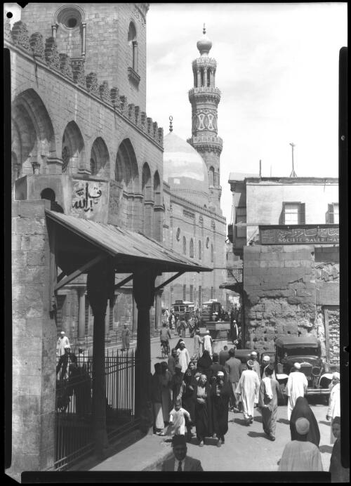 The Mosque Barquq Cairo [with crowds of people, and vehicles on a street] [picture] : [Cairo, Egypt, World War II] / [Frank Hurley]