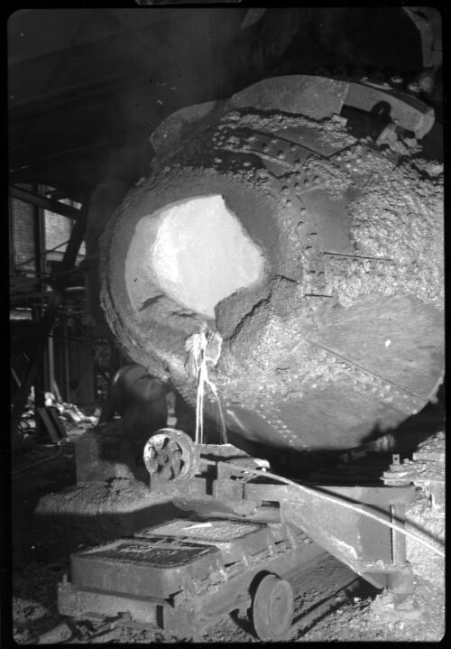 Pouring blister copper containing gold from the converter vessel into moulds at Mount Morgan [Queensland, 2] [picture] / [Frank Hurley]